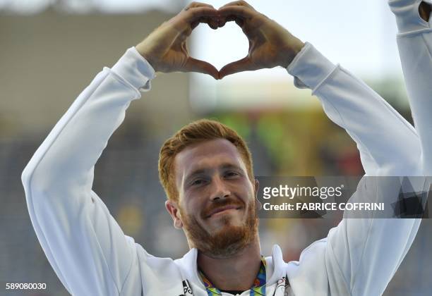Gold medallist Germany's Christoph Harting celebrates on the podium for Men's Discus Throw athletics event at the Rio 2016 Olympic Games at the...