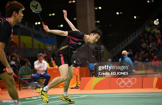 South Korea's Lee Yong Dae and South Korea's Yoo Yeon Seong return during their men's doubles qualifying badminton match against Russia's Vladimir...