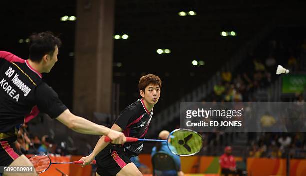 South Korea's Lee Yong Dae and South Korea's Yoo Yeon Seong return during their men's doubles qualifying badminton match against Russia's Vladimir...