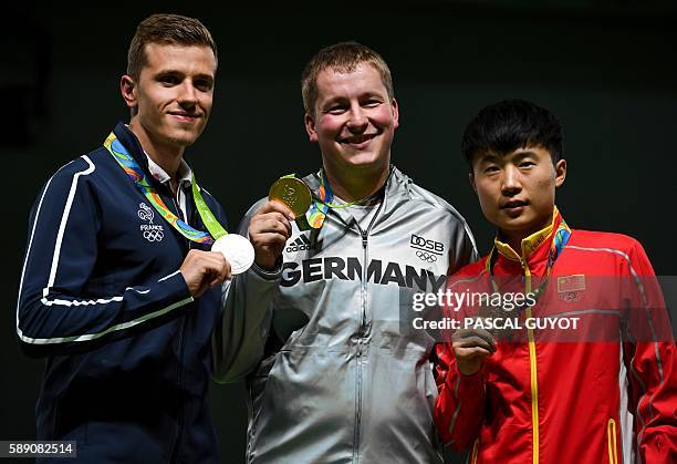 Silver medallist France's Jean Quiquampoix, gold medal winner Germany's Christian Reitz and bronze medallist China's Li Yuehong stand on the podium...