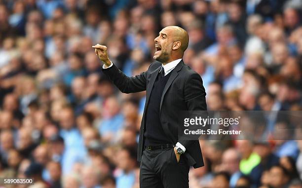 Josep Guardiola, Manager of Manchester City shouts instructions to his players on the pitch during the Premier League match between Manchester City...