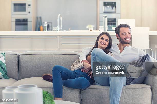 portait of couple relaxing on the sofa. - new sofa stock pictures, royalty-free photos & images