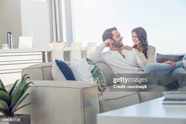 paar entspannen donerauf dem sofa. - contemporary couple stock-fotos und bilder