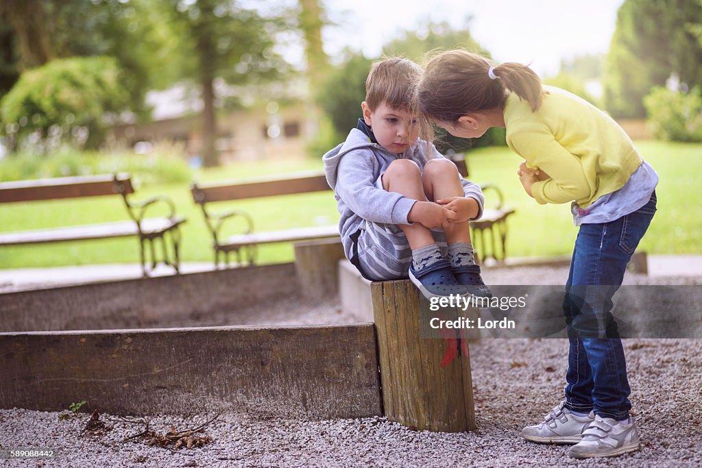 Garota apoiando menino triste sentado sozinho