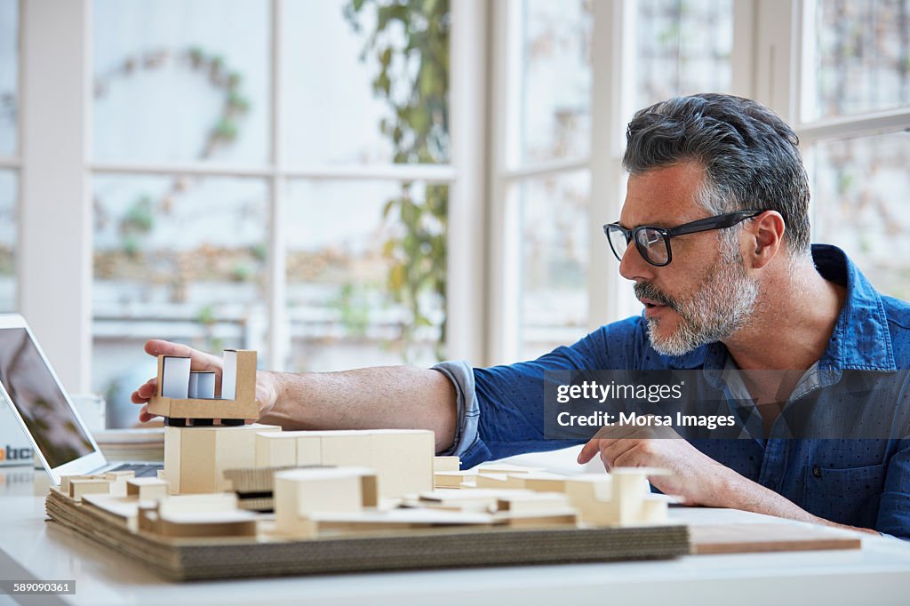 Architect working on model at desk