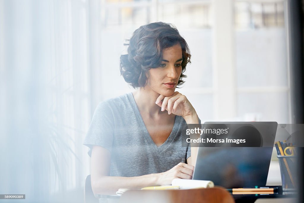 Businesswoman using laptop in office