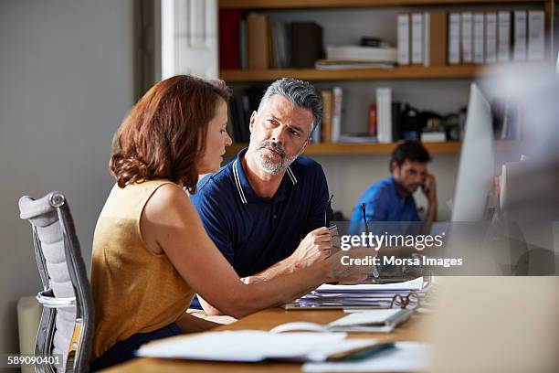 business people discussing at desk - talking serious stock pictures, royalty-free photos & images