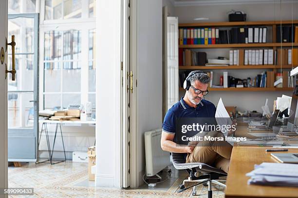 businessman examining documents at desk - audio equipment imagens e fotografias de stock