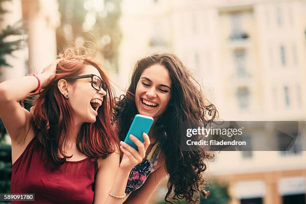 due amici che es texting all'aperto - dyed red hair foto e immagini stock