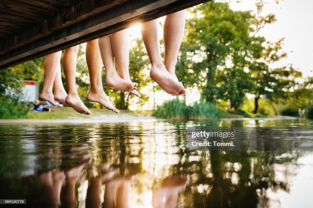 Four young people sitting on a jetty