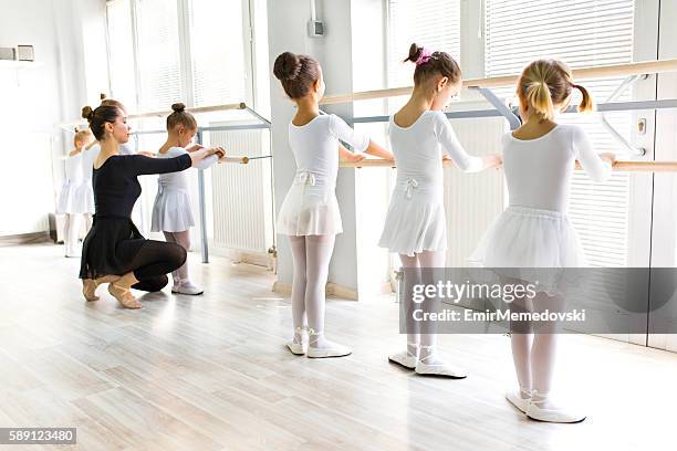 insegnante di balletto che aiuta le ragazze con posture durante le lezioni di balletto. - dance teacher foto e immagini stock