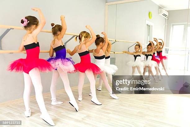 little ballerinas in tutu using barre and practicing postures. - barre class bildbanksfoton och bilder