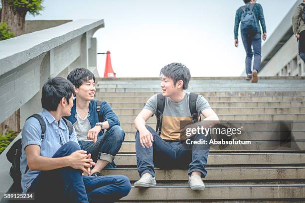 three japanese students discussing on staircase, campus, kyoto, japan, asia - japanese tree stockfoto's en -beelden