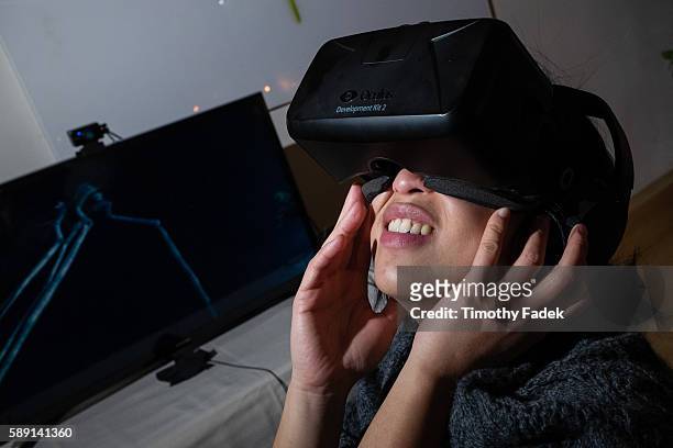 Woman wears a virtual reality headset / goggles / visor made by Oculus Rift, and experiences a virtual reality tour of the Salvador Dali Museum....