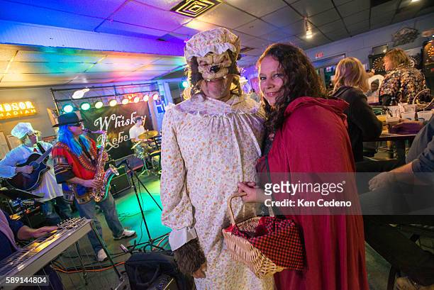 In Halloween costumes, the Big Bad Wolf and Little Miss Riding Hood pose for a photo while celebrating at the local bar The Sports Den where Whiskey...