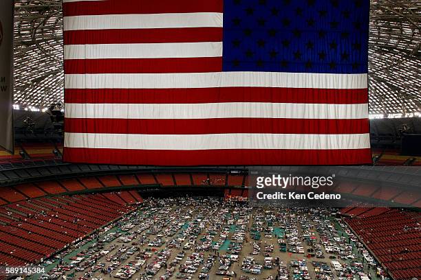 The American flag hangs above the crowd of 16,000 displaced New Orleans citizens as a result of Hurricane Katrina, during their temporary housing at...