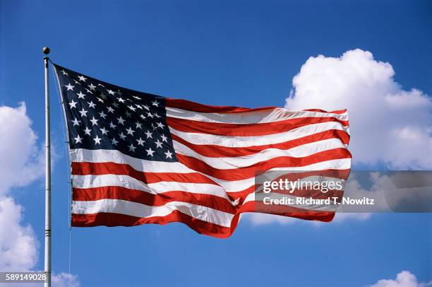 american flag blowing in the wind - amerikanische flagge stock-fotos und bilder