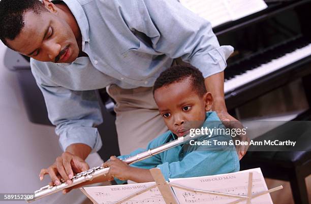 dad teaching his son to plate the flute - african flutes stock pictures, royalty-free photos & images