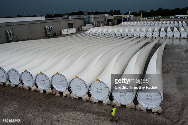 Worker walks past finished blades awaiting transport at the Siemens wind turbine blade plant in Fort Madison, Iowa. Photograph: Timothy Fadek