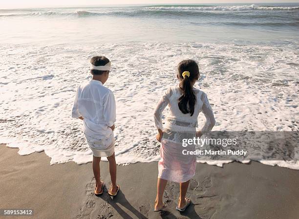 children wearing traditional dress at the beach - nyepi stock pictures, royalty-free photos & images