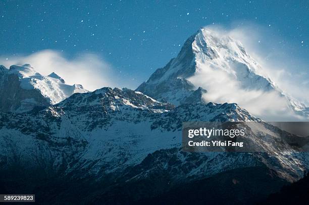 snowy peak under starlit sky - schneebedeckt stock-fotos und bilder