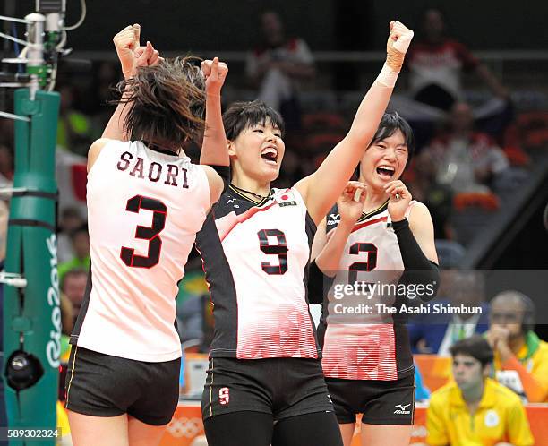 Saori Kimura, Haruyo Shimamura and Haruka Miyashita of Japan celebrate a point during the Women's preliminary volleyball match between Japan and...