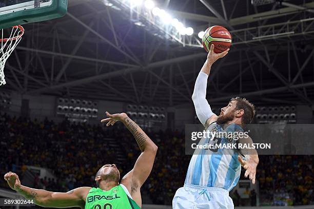 Argentina's small forward Andres Nocioni takes a shot over Brazil's power forward Rafael Hettsheimeir during a Men's round Group B basketball match...