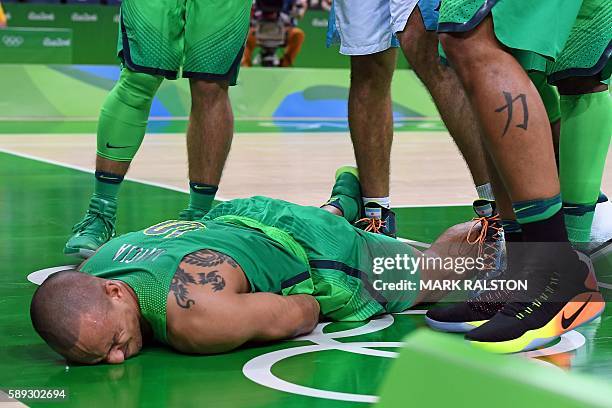 Brazil's small forward Alex Garcia lies on the floor after falling during a Men's round Group B basketball match between Argentina and Brazil at the...