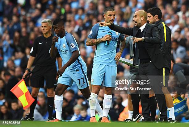 Josep Guardiola, Manager of Manchester City gives Aleksander Kolorov of Manchester City instructions during the Premier League match between...