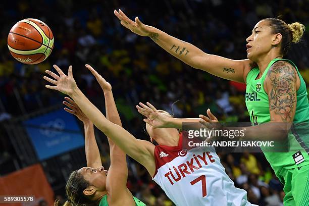 Brazil's point guard Adriana Moises, Turkey's point guard Birsel Vardarli Demirmen and Brazil's centre Erika Souza go for a rebound during a Women's...