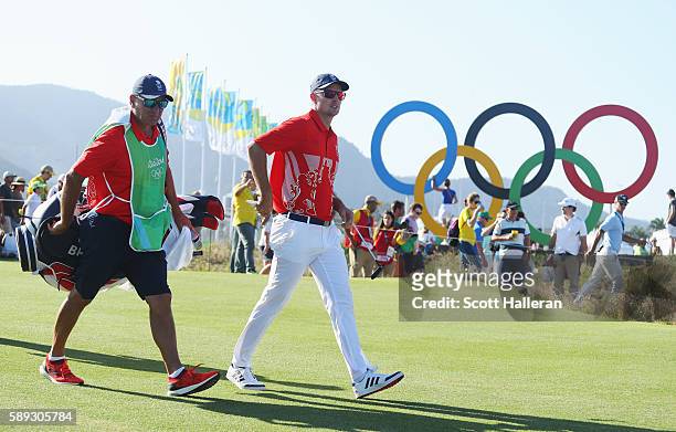 Justin Rose of Great Britain and his caddie Mark Fulcher walk to the 17th green during the third round of the golf on Day 8 of the Rio 2016 Olympic...
