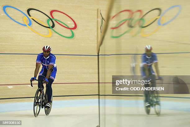 France's Gregory Bauge is refelcted in a glass barrier after competing in the men's Sprint quarter-finals track cycling event at the Velodrome during...