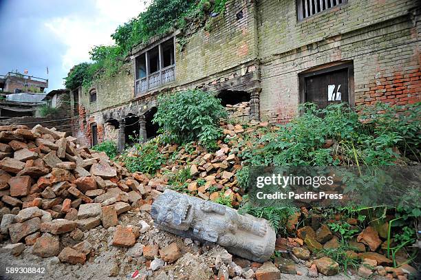 Broken stone lion sculpture thrown around the premises as bushes and grasses grow taller around Heritage monuments at Bungamati, Patan. Due to the...