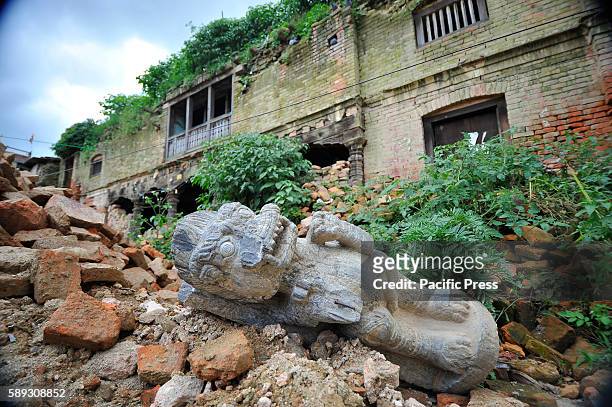 Broken stone lion sculpture thrown around the premises as bushes and grasses grow taller around Heritage monuments at Bungamati, Patan. Due to the...