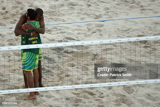 Pedro Solberg of Brazil embraces his teammate Evandro Goncalves Oliveira Junior after being defeated in a Men's Round of 16 match against Russia on...