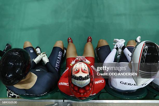 Photo shows a face painted onto the helmet of China's Zhong Tianshi as she waits with other cyclists to compete in the women's Keirin second round...
