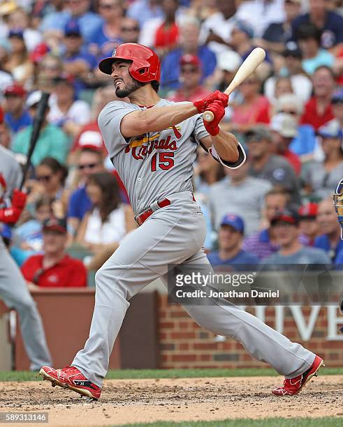 Randal Grichuk of the St. Louis Cardinals follows the flight of his grand slam home run in the 8th inning against the Chicago Cubs at Wrigley Field...