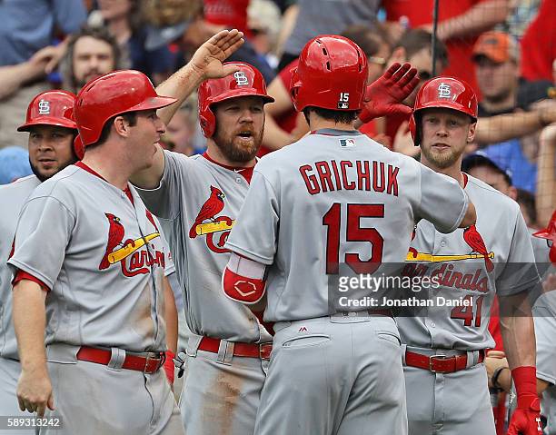Randal Grichuk of the St. Louis Cardinals is greeted by Jedd Gyorko, Brandon Moss and Jeremy Hazelbaker after hitting a grand slam home run in the...