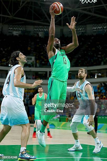 Nene Hilario of Brazil heads for the net as Luis Scola and Andres Nocioni of Argentina defend during the Men's Preliminary Round Group B match on day...