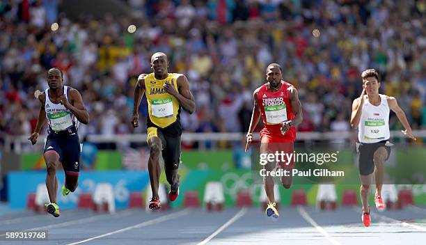James Dasaolu of Great Britain, Usain Bolt of Jamaica and Richard Thompson of Trinidad and Tobago compete in round one of the Men's 100 Meters on Day...