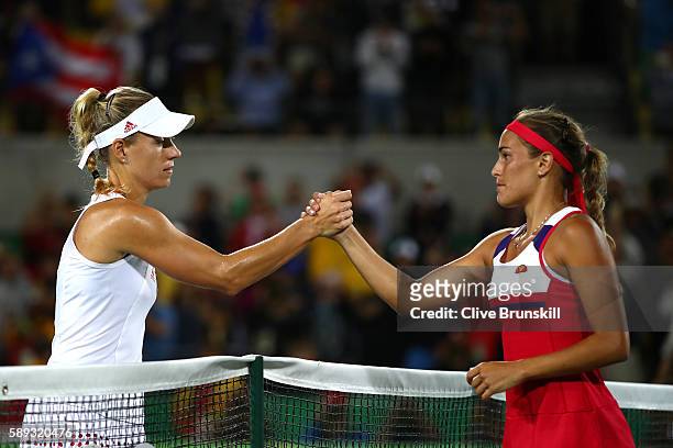Monica Puig of Puerto Rico shakes hands with Angelique Kerber of Germany after the Women's Singles Gold Medal Match on Day 8 of the Rio 2016 Olympic...