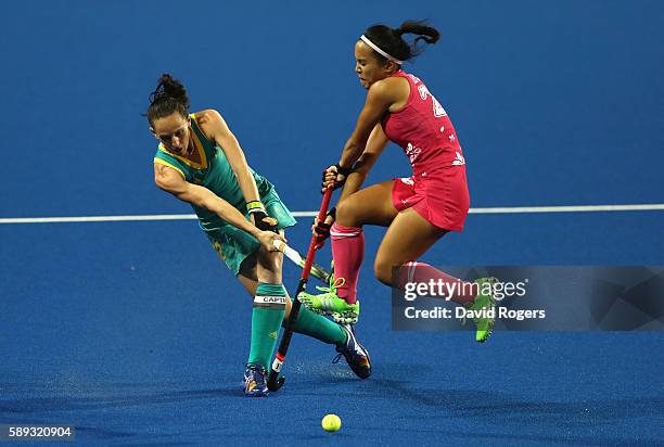 Madonna Blyth of Australlia plays the ball past Motomi Kawamura during the Women's Pool B hockey match between Australia and Japan on Day 8 of the...