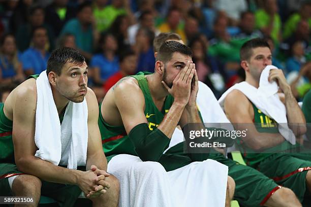 Jonas Maciulis, Jonas Valanciunas and Mantas Kalnietis of Lithuania react on the bench during the Men's Preliminary Round Group B between Spain and...