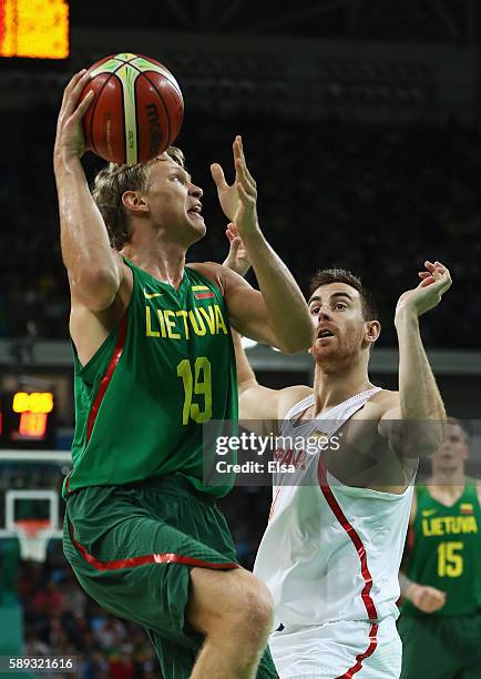 Mindaugas Kuzminskas of Lithuania looks to shoot against Victor Claver of Spain during the Men's Preliminary Round Group B between Spain and...