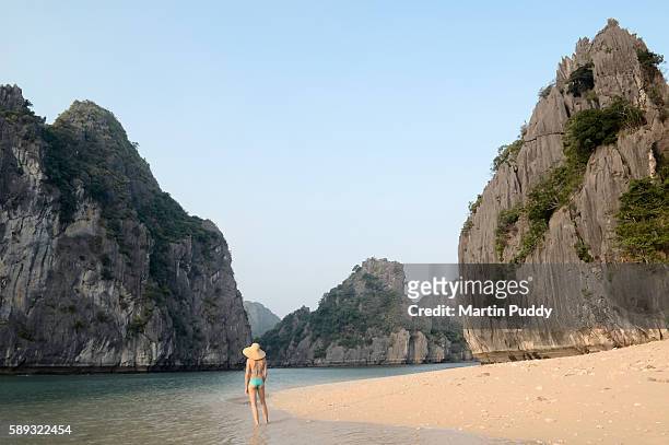 woman in a bikini standing on small beach in halong bay - vietnam beach stock pictures, royalty-free photos & images