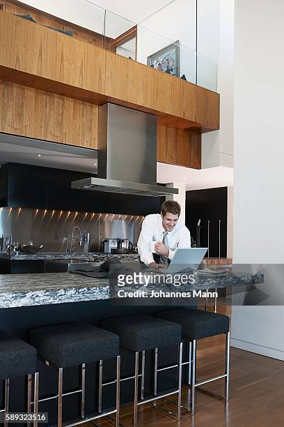 businessman using laptop computer in kitchen - business mann laptop stock pictures, royalty-free photos & images