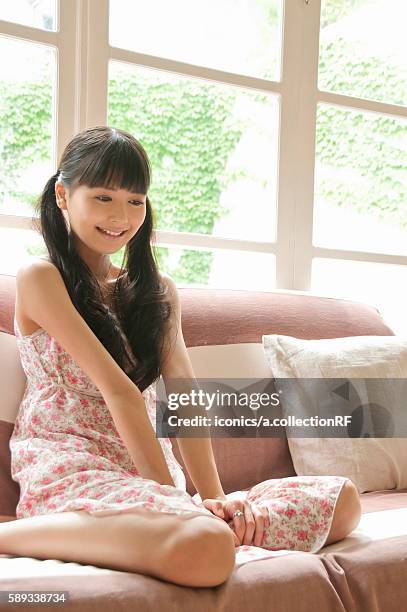 young woman sitting on sofa - råttsvans bildbanksfoton och bilder