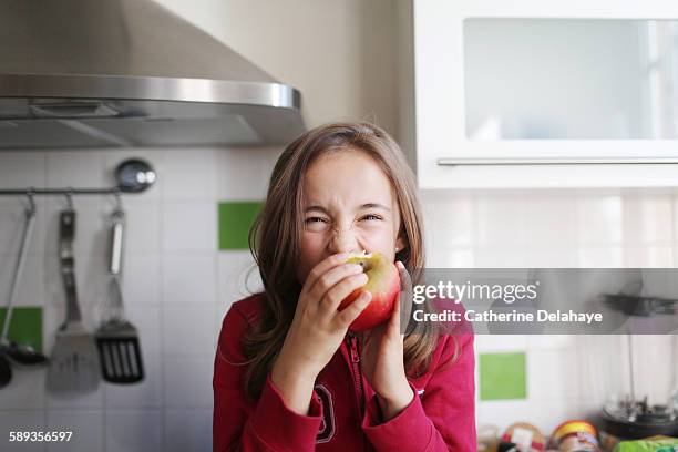 a 10 years old girl eating an apple - 10 11 years photos stock pictures, royalty-free photos & images