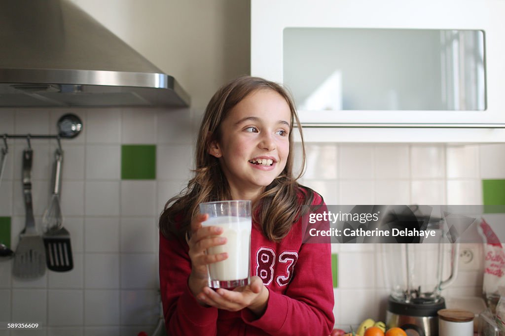 A 10 years old girl with a glass of milk