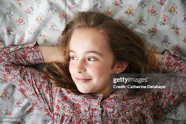 a 10 years old girl lying on her bed - 10 years stockfoto's en -beelden